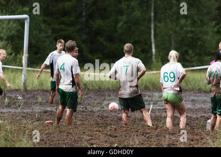 Hyrynsalmi, Finland, July 16 2016. The Swamp Soccer World Championship 2016 at Ukkohalla in Hyrnsalmi. About 2000 competitors take part every year in the world's oldest swamp soccer tournament. Pictured: Action and crowd scenes from the knockout stages on the rainy second day. Credit:  Rob Watkins/Alamy Live News Stock Photo