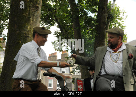 London, UK. 16th July, 2016. Chopper pours tea into Gordon's cup, during the Bicycle Tea Pouring event, at the 2016 Chap Olympiad in London's Bedford Square. Credit:  Dario Earl/Alamy Live News Stock Photo