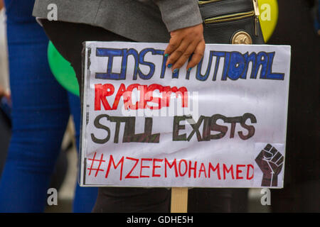 Institutional Racism still Exists placard in Liverpool, Merseyside, UK. 16th July, 2016. Mzee Mohammed Protest. Family and mourners protest through the streets of Liverpool after the death of 18yr old Mzee Mohammed, whilst in police custody. The youth was allegedly seen 'behaving erratically' in the Liverpool One shopping centre by security staff. The IPCC have begun an investigation into the teens untimely death. Credit:  Cernan Elias/Alamy Live News Stock Photo