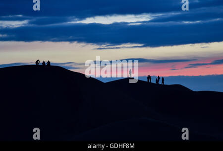 Ordos, China's Inner Mongolia Autonomous Region. 15th July, 2016. Silhouettes of tourists are seen on sand dunes at the Whistling Dune Bay in Dalad Qi in Ordos, north China's Inner Mongolia Autonomous Region, July 15, 2016. Located in the east of Kubuqi Desert, the Whistling Dune Bay was developed as a tourist destination since 1984. After years of improvement, it became a landmark for tourism industry of the Inner Mongolia Autonomous Region. © Lian Zhen/Xinhua/Alamy Live News Stock Photo