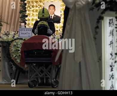 Hong Kong, An official police funeral with full honor was held here Sunday for Thomas Cheung. 25th June, 2016. A colleague of Thomas Cheung presents a helmet used by Thomas during his funeral held at the Universal Funeral Parlor in Hung Hom in south China's Hong Kong, July 17, 2016. An official police funeral with full honor was held here Sunday for Thomas Cheung, a 30-year-old senior station officer who died while battling fire in an industrial building in Hong Kong's East Kowloon on June 25, 2016. © Wang Shen/Xinhua/Alamy Live News Stock Photo