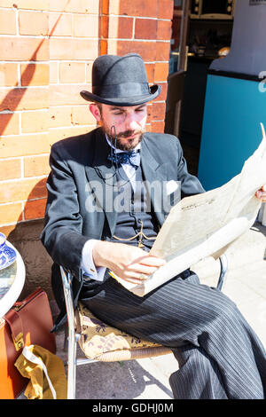 Well dressed man reading newspaper wearing monocle  suit smart smartly dressed pin stripe suit bow tie vintage look attire 1940's look Credit:  Tommy  (Louth)/Alamy Live News Stock Photo