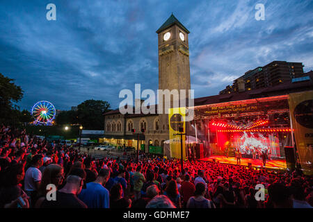 Dramatic sky behind the tower of Maryland Institute College of Art's Mt. Royal Station building as the Mighty Mighty Bosstones play on the main stage at Artscape, July 16, 2016, in Baltimore MD. Artscape is the largest free arts festival in the United States. Stock Photo