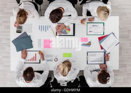 Business people discussing the charts and graphs showing the results of their successful teamwork Stock Photo