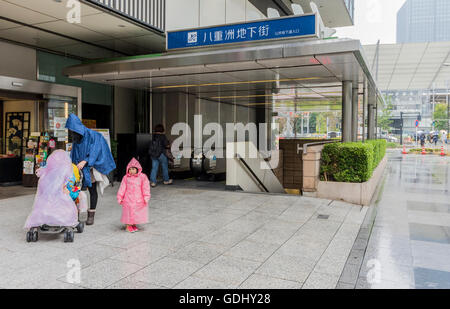 People taking cover on rainy day in Tokyo Japan near main railway station Stock Photo