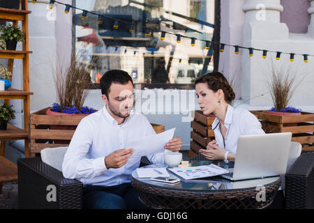 business people conflict working problem, angry boss argue scream to colleague businessmen and women serious argument negative emotion discussing report meeting at outdoors cafe during the lunch break Stock Photo