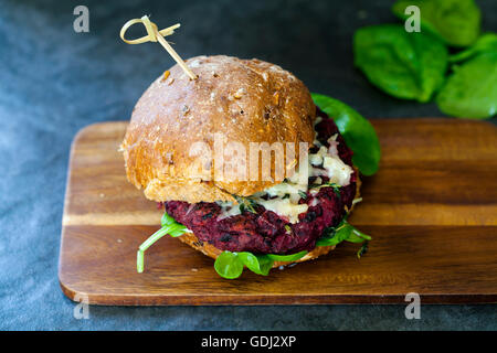 Beetroot and black bean burger with melted cheese and thyme Stock Photo