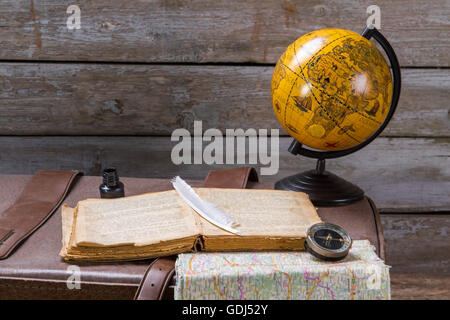 Feather on book beside inkwell. Stock Photo
