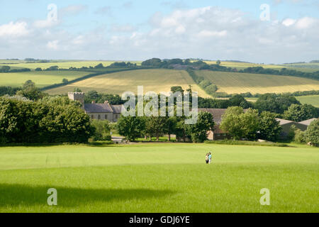 A couple standing using a selfie stick amidst crops in the East Sussex South Downs outside the village of Falmer Stock Photo