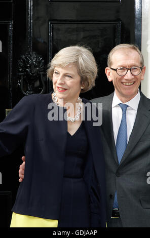 Theresa May and her husband Philip gesture for the media outside the door of 10 Downing St before entering for the first time. Stock Photo