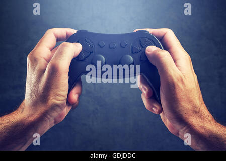 Man using game pad controller to play entertaining electronics video games, gaming and entertainment concept Stock Photo