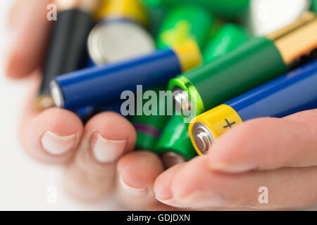 close up of hands holding alkaline batteries heap Stock Photo