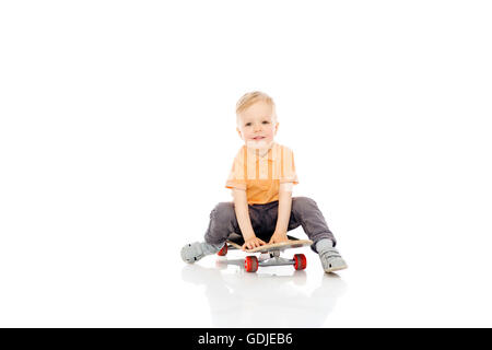 happy little boy sitting on skateboard Stock Photo