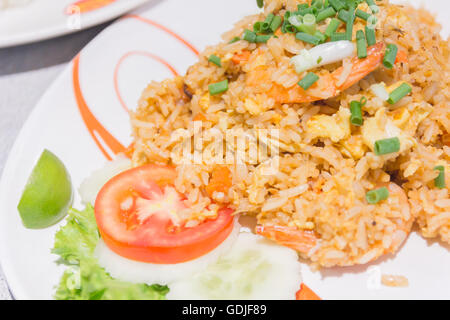Homemade Chinese fried rice with vegetables, chicken and fried eggs served on a plate (Selective Focus, Focus one third into the Stock Photo