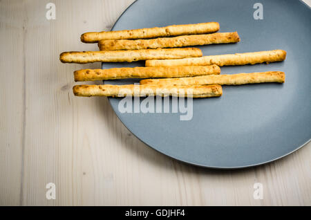 rustic breadsticks in a dish on wood table, close up, background Stock Photo