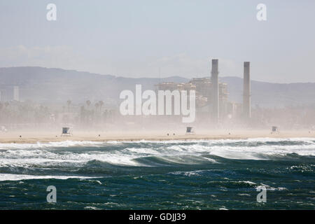 AES Huntington Beach Generating Station seen from Huntington Beach Pier with heavy spray caused by strong winds blowing onshore Stock Photo