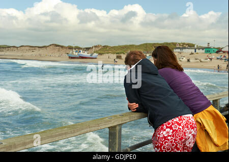 Two female tourists looking at the beach from the pier Stock Photo