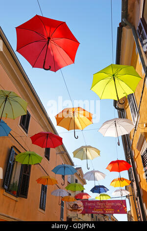 Open umbrellas hanging from strings in the street of Novigrad Stock Photo