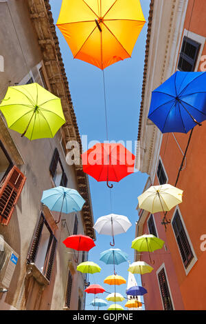 Open umbrellas hanging from strings in the street of Novigrad Stock Photo