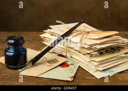 Vintage ink well and fountain pen on a table with old letters Stock Photo