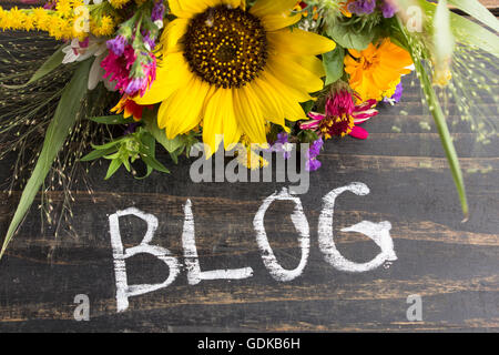 Word Blog with Summer Flowers on a Rustic Wooden Background. Stock Photo