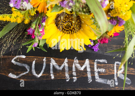 Word Summer with Summer Flowers on a Rustic Wooden Background. Stock Photo