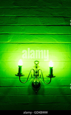 Green, toxic chandelier, lantern powered on hanging on the wall in portrait format Stock Photo