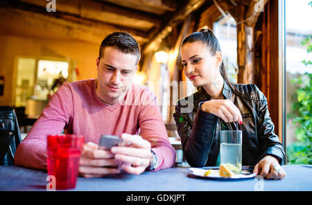 Young beautiful couple sitting in a bar or club Stock Photo