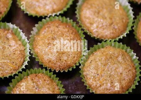 Carrot Cupcakes. Homemade Carrot muffins in green muffin paper served on a brown dish. Stock Photo