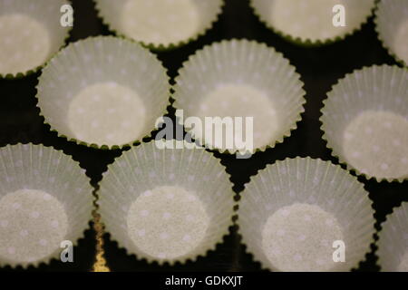 Muffin Paper. Empty muffin paper - top view. Cupcake paper, muffin shape arranged on a baking pan, ready for homemade carrot maffins dough. Stock Photo