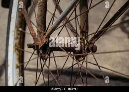 Close up of the front rusty wheel and axis of a vintage bicycle