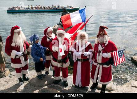 Copenhagen, Denmark – July 18, 2016:  Santa Claus’ participating in the World Santa Claus Congress 2016 visits the harbor promenade, Langelinie, where the sculpture, The Little Mermaid is placed. At the photo are Santa's from USA, France, Japan and Canada. The congress has taken place since 1957. The venue and organizer is Bakken, the world’s oldest amusement park and located north of Copenhagen. Credit:  OJPHOTOS/Alamy Live News Stock Photo