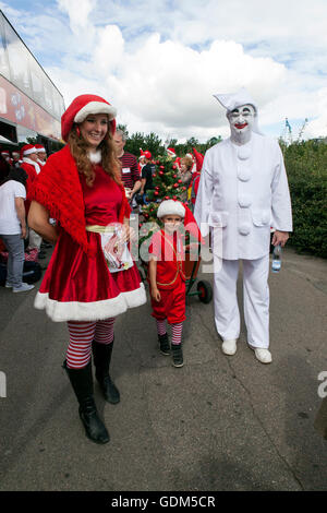Copenhagen, Denmark – July 18, 2016:  Santa Claus’ participating in the World Santa Claus Congress 2016 visits the harbor promenade, Langelinie, where the sculpture, The Little Mermaid is placed, and hands out hands out candy to kids. They also had some serious talks to the kids about the upcoming Christmas and whish list. At the photo Bakken's iconic Pjerrot (R) the clown assists at the tour. The congress has taken place since 1957. The venue and organizer is Bakken, the world’s oldest amusement park and located north of Copenhagen. Credit:  OJPHOTOS/Alamy Live News Stock Photo