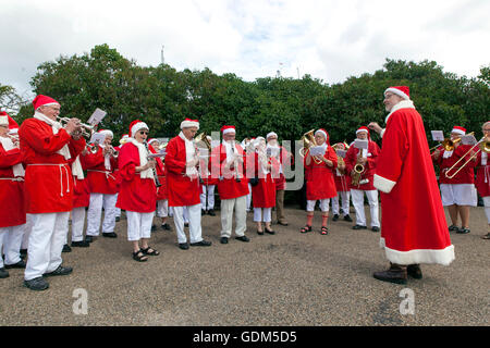 Copenhagen, Denmark – July 18, 2016:  Santa Claus’ participating in the World Santa Claus Congress 2016 visits the harbor promenade, Langelinie, where the sculpture, The Little Mermaid is placed, and hands out hands out candy to kids. At the photo a Santa band is warming up with Christmas tunes. The congress has taken place since 1957. The venue and organizer is Bakken, the world’s oldest amusement park and located north of Copenhagen. Credit:  OJPHOTOS/Alamy Live News Stock Photo
