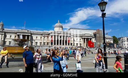 Trafalgar Square, London, UK 18 July 2016 - Tourists and locals bask in glorious sunshine during lunchtime in Trafalgar Square on the hot day in the capital as temperatures are predicted to soar to 30 degrees celsius. Credit:  Dinendra Haria/Alamy Live News