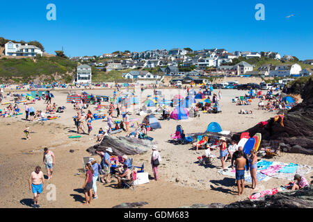 Polzeath, Cornwall, U.K. 18th July 2016. Surfers and families flock to the beach on a hot and sunny day in Cornwall. Situated on North Cornwall's Atlantic coast,  Polzeath is a popular location for surfers.  Credit:  Mark Richardson/Alamy Live News Stock Photo