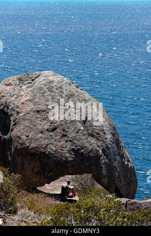 A person sitting on a rock reading, Lucky Bay, Esperance Western Australia Stock Photo
