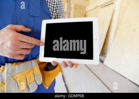 Construction worker pointing at digital tablet close-up Stock Photo