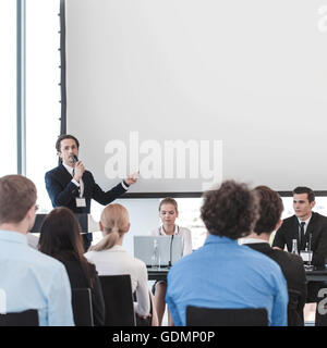 Business people speaking at presentation in microphone in office Stock Photo