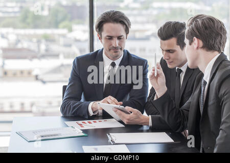 Businessmen working together in office with financial reports and digital tablet pc Stock Photo