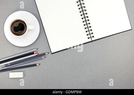 office desk table with open spiral notebook, supplies and coffee cup Stock Photo