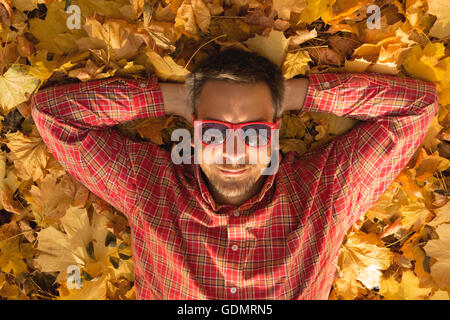 Guy lying on the ground and enjoying fall season Stock Photo
