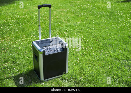 Cordless transportable festival music player on a grass lawn in a park Stock Photo