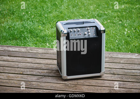 Cordless transportable festival music player standing outdoor on a decayed wood terrace Stock Photo