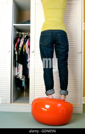 Girl doing putting clothes away Stock Photo