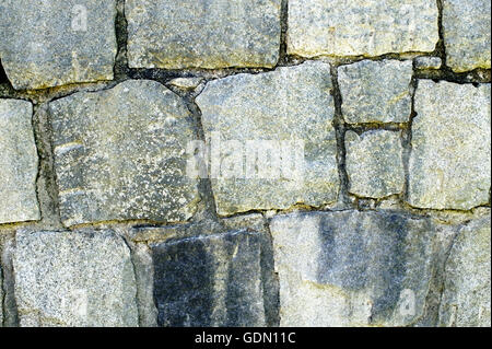 Closeup of a gray cut stone wall background with irregular shapes Stock Photo