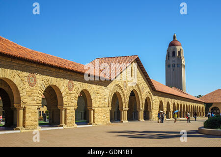 Arched Sandstone and Tile Roof Buildings on the Stanford Main Quad with Hoover Tower in the background a Sunny Cloudless day Stock Photo