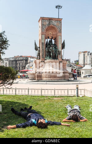 Istanbul, Turkey - July 1, 2016: Young homeless men sleep on Taksim square near the Republic Monument Stock Photo