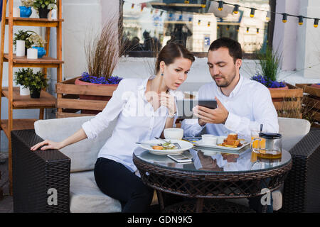 Business people looking at digital tablet in cafe during a meeting Stock Photo