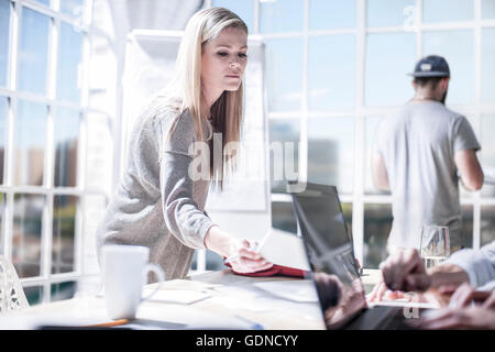 Female designers handing over paperwork in design studio Stock Photo